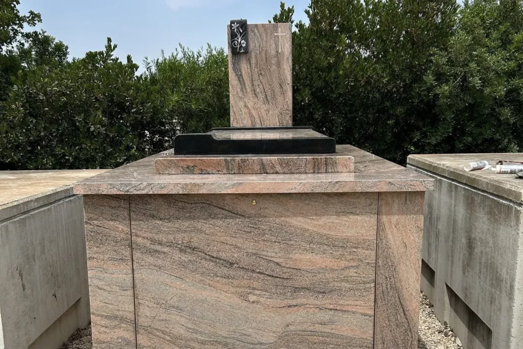 Monument funéraire en granit rose et stèle gravée dans un cimetière