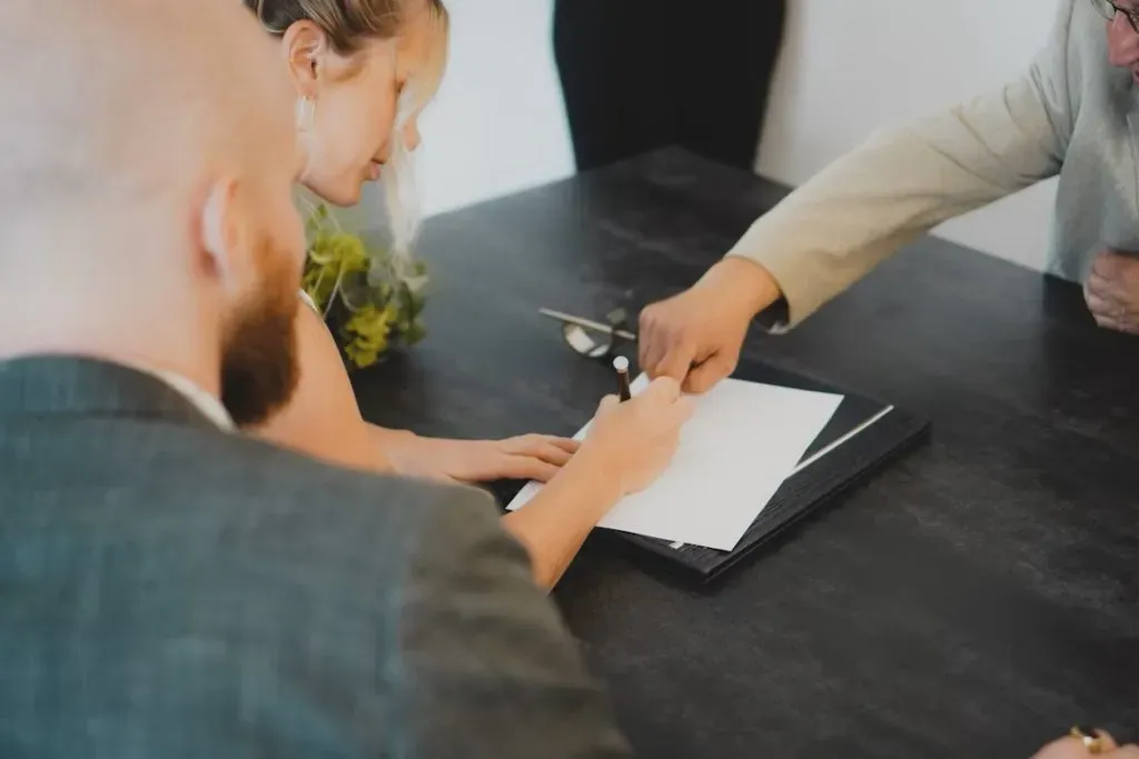 Signature d'un contrat de prévoyance obsèques entre un couple et un conseiller funéraire